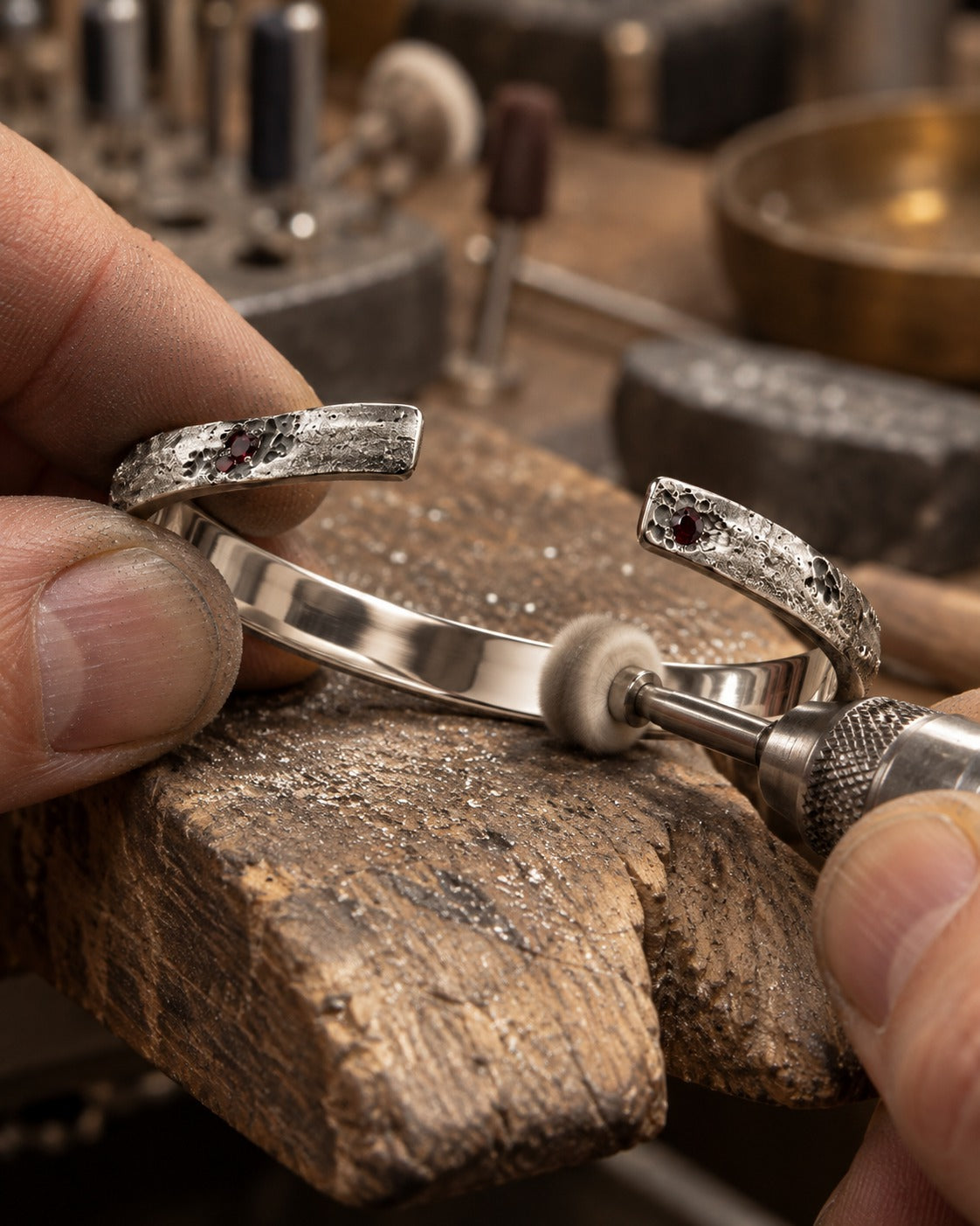 Silver cuff with rubies being polished on the bench