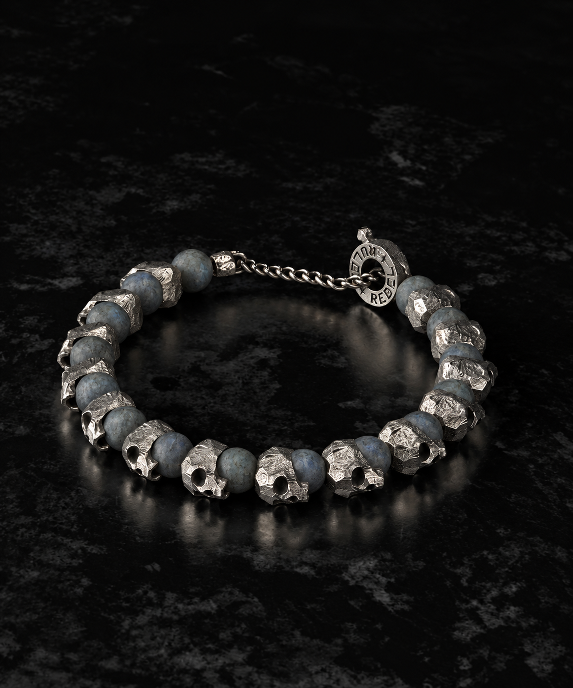 Raw I Bracelet, Labradorite Matte and skull beads laid in a circle on dark stone