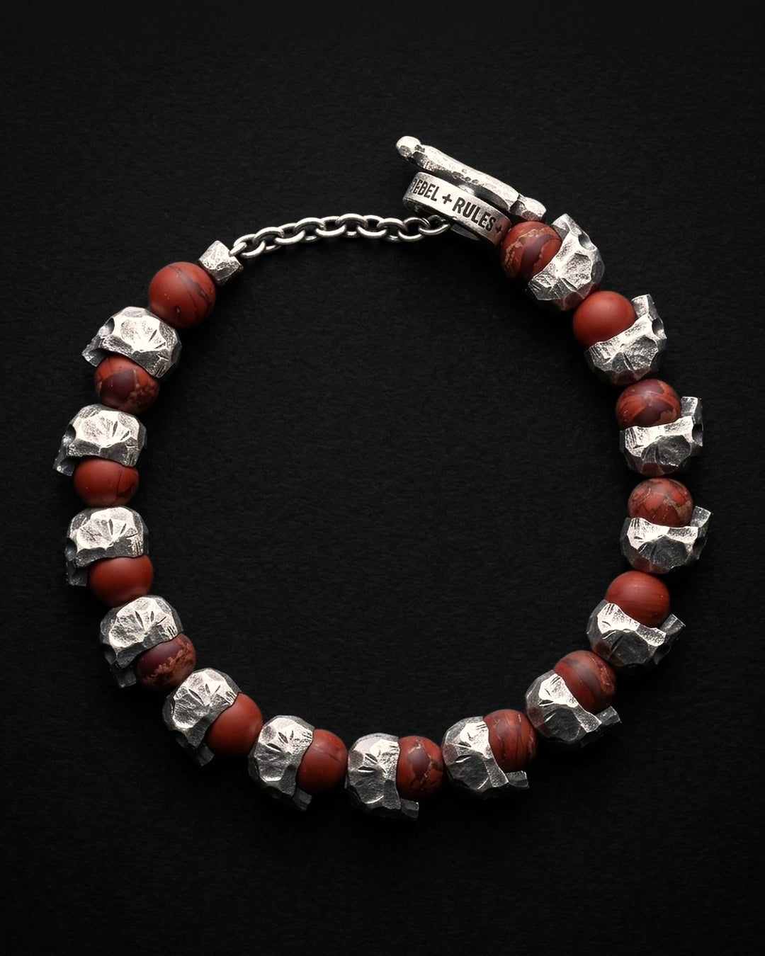 Raw I Bracelet in Red Brecciated Matte from above, the skull and red beads in a circle with the toggle clasp