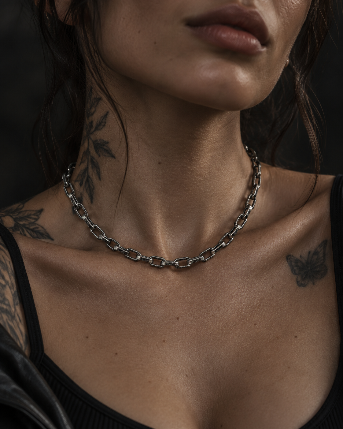 Raw I Necklace worn on a woman with tattooed shoulders and a black tank top