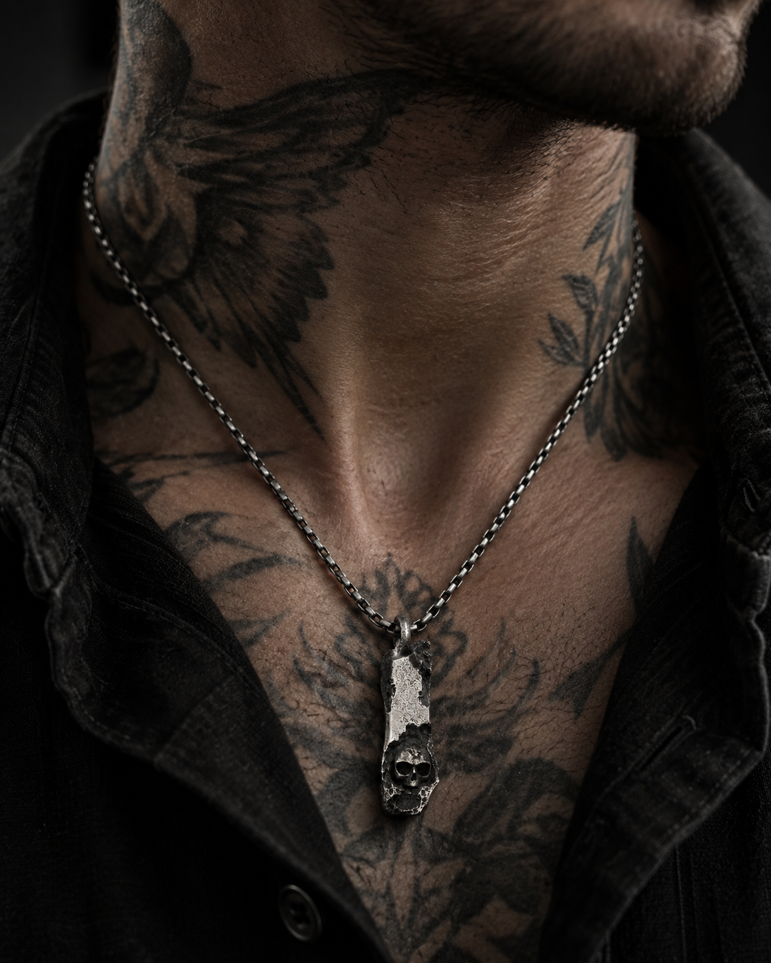 Raw I Pendant worn on a tattooed neck and chest under an open black shirt