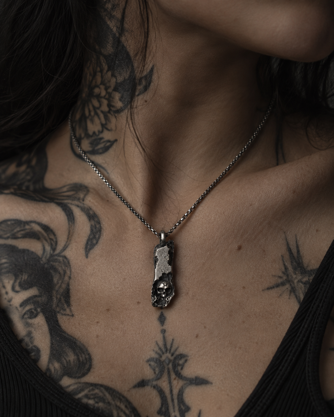 Raw I Pendant on a tattooed chest, the chain sitting over the collarbones