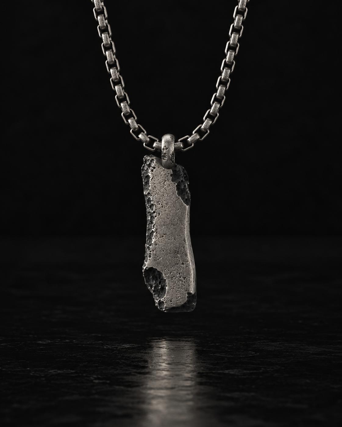 Raw I Pendant turned to its smooth back, chipped edges catching the light