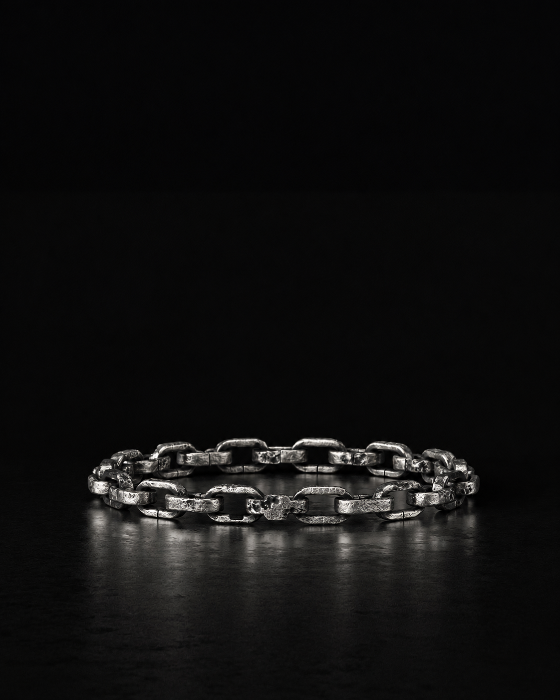 Raw II Bracelet laid flat in a straight line on a dark reflective surface