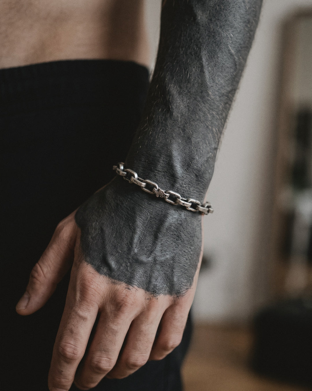 Raw II Bracelet, cast silver chain links, worn on a man's wrist with a solid blackwork tattoo
