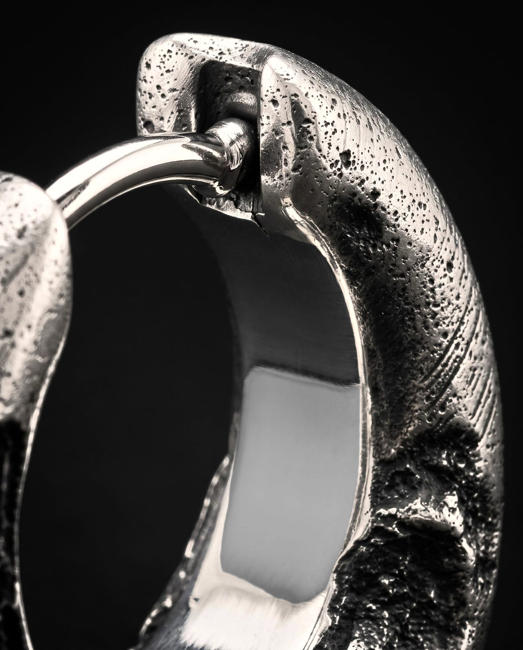 Raw III Earring up close, the fine polished pin of the click hinge and the mirror-polished inside of the hoop