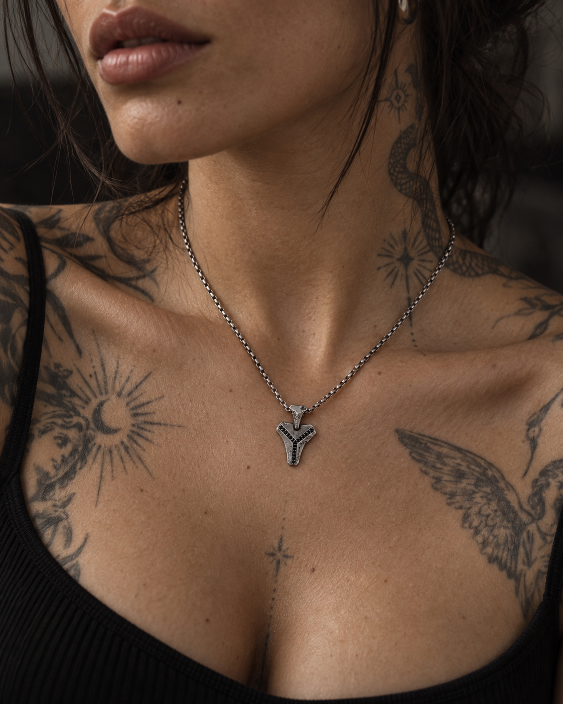 Raw III Pendant worn on a chain by a woman with tattooed shoulders and chest, black top
