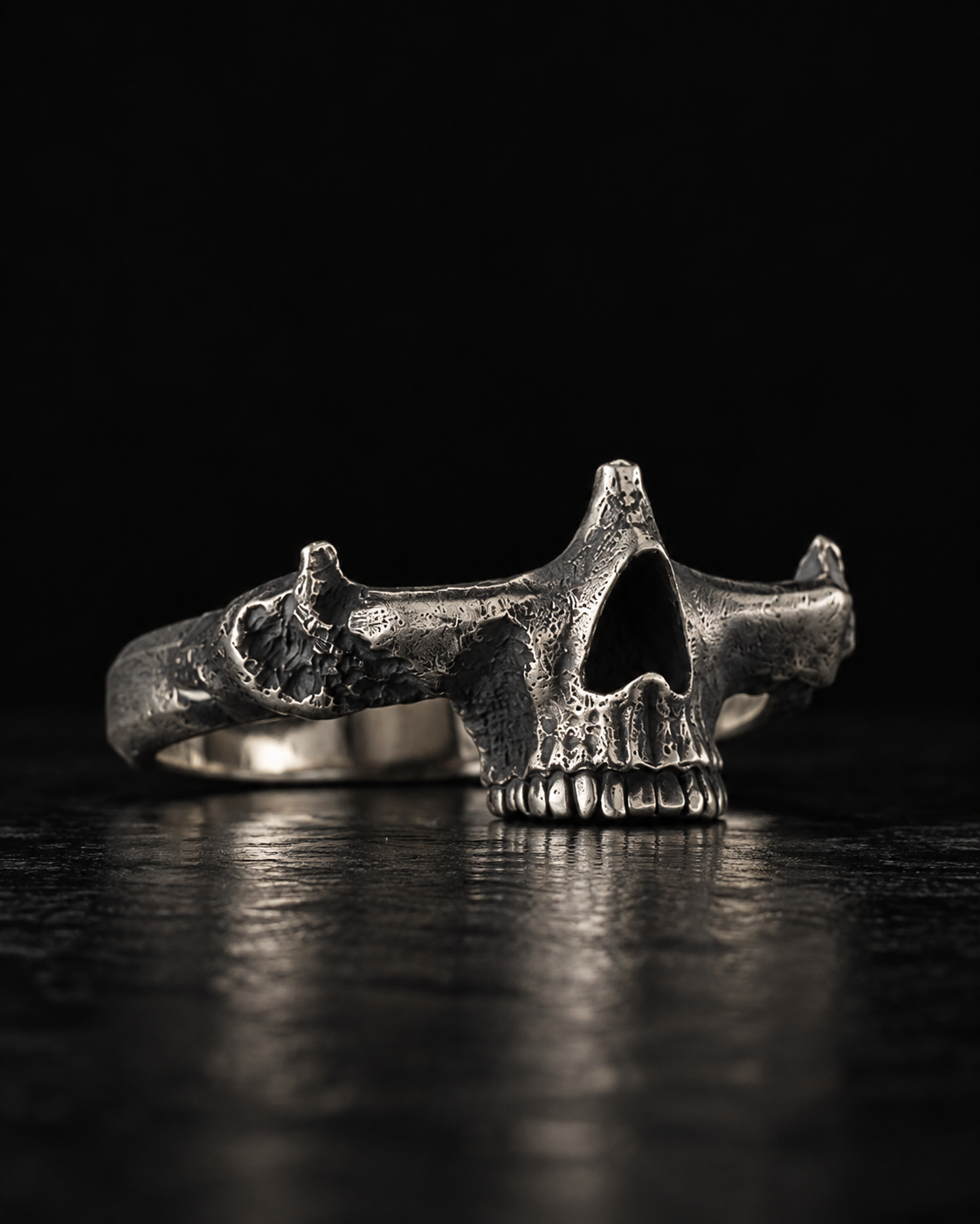 Raw IV Ring at an angle, hollow eye socket and a row of teeth above the band