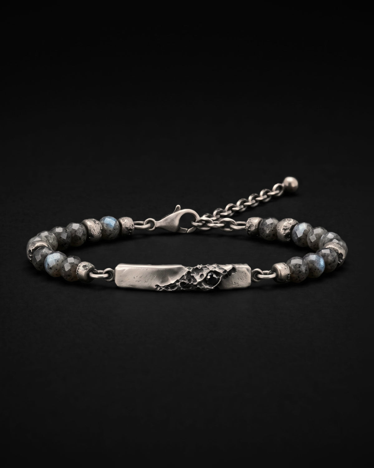 Raw V Bracelet con perle sfaccettate di labradorite e distanziatori d'argento con crateri, la barra con crateri e il suo spinello nero in primo piano