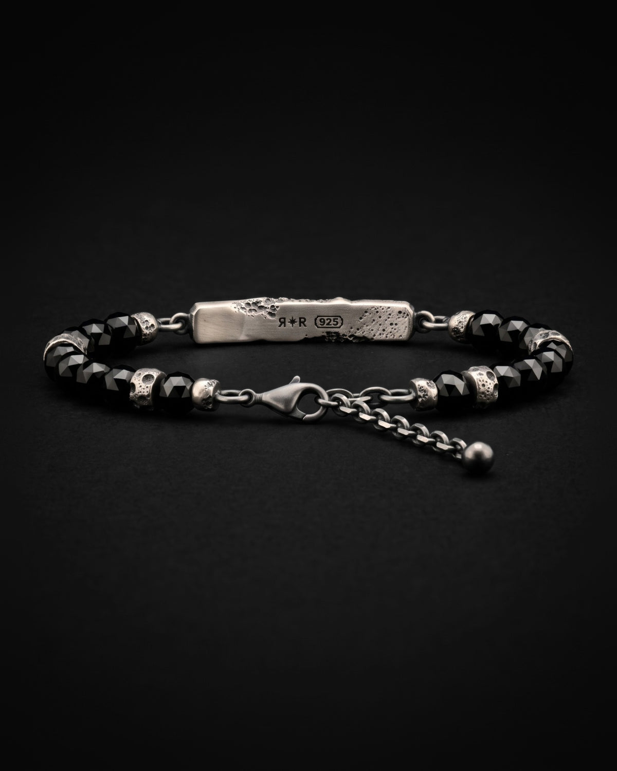 Raw V Bracelet visto da dietro, la stella RR e i punzoni 925 incisi al laser sulla faccia interna della barra, con perle di spinello nero
