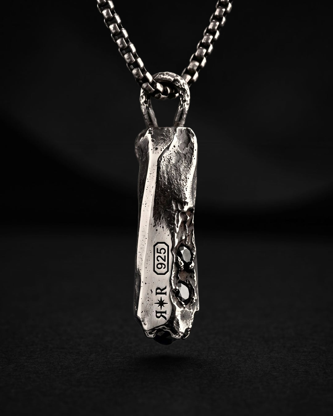 Raw V Pendant from behind, the RR star hallmark and 925 laser engraved along the prism beside two black spinels