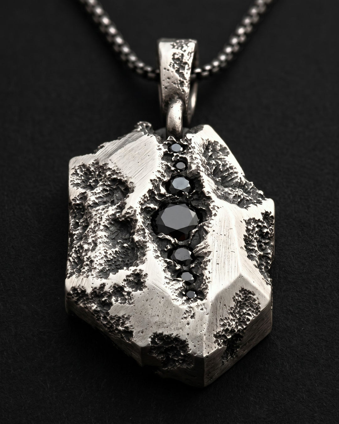 Raw VI Pendant seen from a low angle, the faceted shard and its line of black stones receding towards the bail