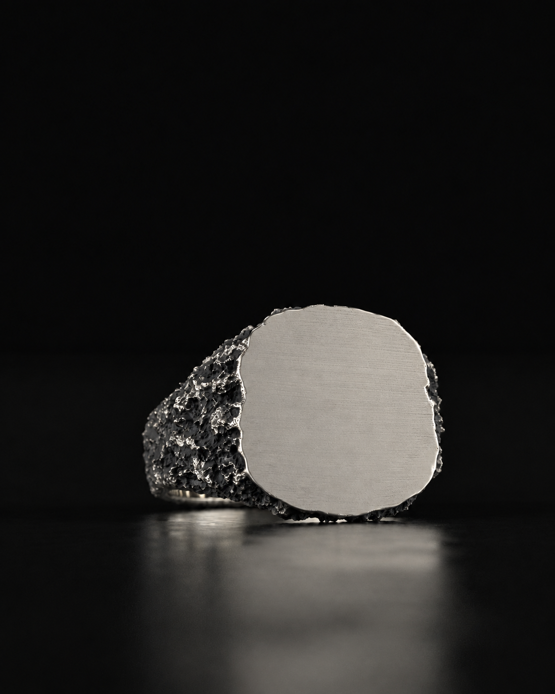Raw VII Ring at a slight angle, brushed flat plate framed by a rough crusted shank