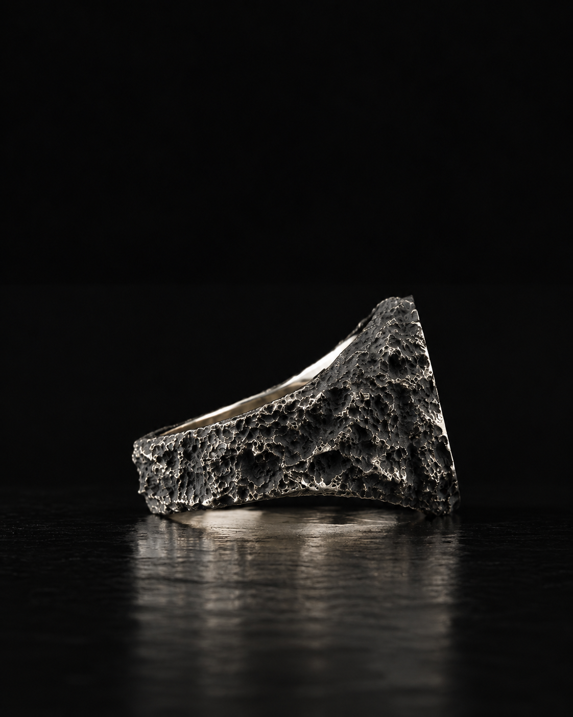 Raw VII Ring side profile from the opposite side, pitted shank on a dark reflective surface