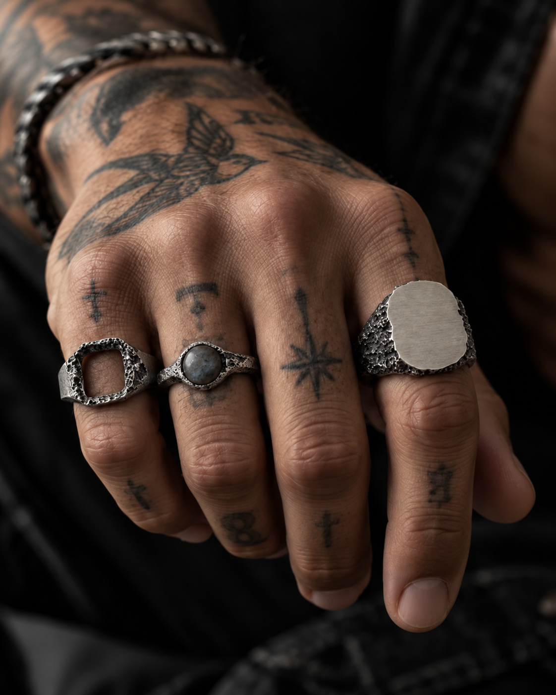 Raw VIII Ring with the labradorite stone worn on a man's tattooed hand, two other silver rings alongside