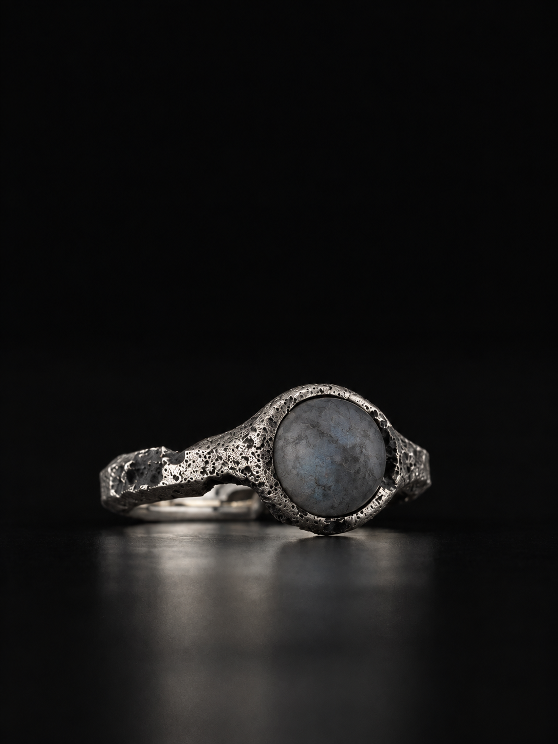 Raw VIII Ring angled to show the labradorite cabochon and the rough, pitted band
