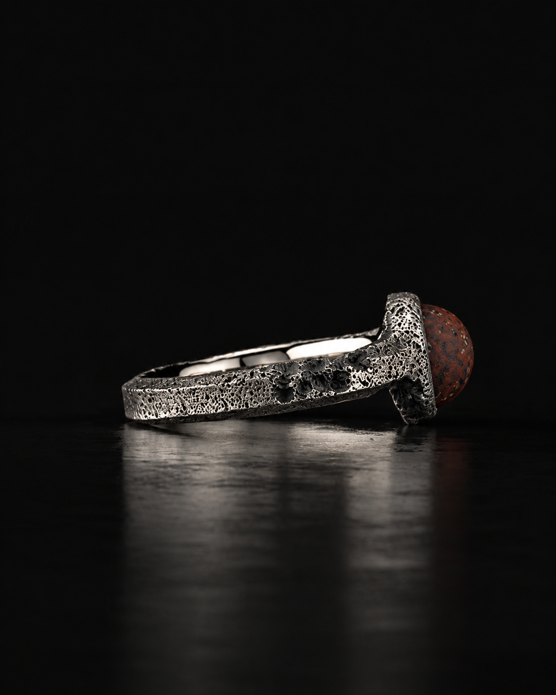 Raw VIII Ring side view with the red brecciated stone at the right and the pitted band running left