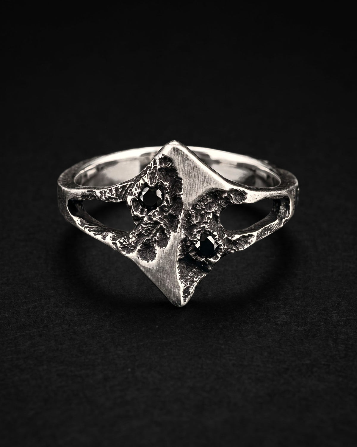 Raw XIX Ring from the front, the satin diamond face between two cratered edges, each with a black spinel