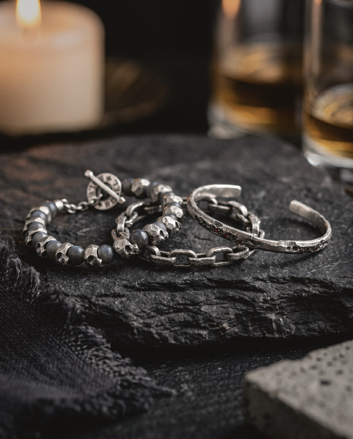 Skull and labradorite bead bracelet, cratered link chain and ruby cuff in raw silver on dark slate